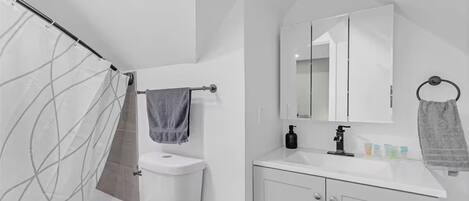 A modern bathroom with a toilet, sink, and shower.