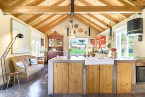 A kitchen with wooden cabinets, a central island, and a hanging light fixture.