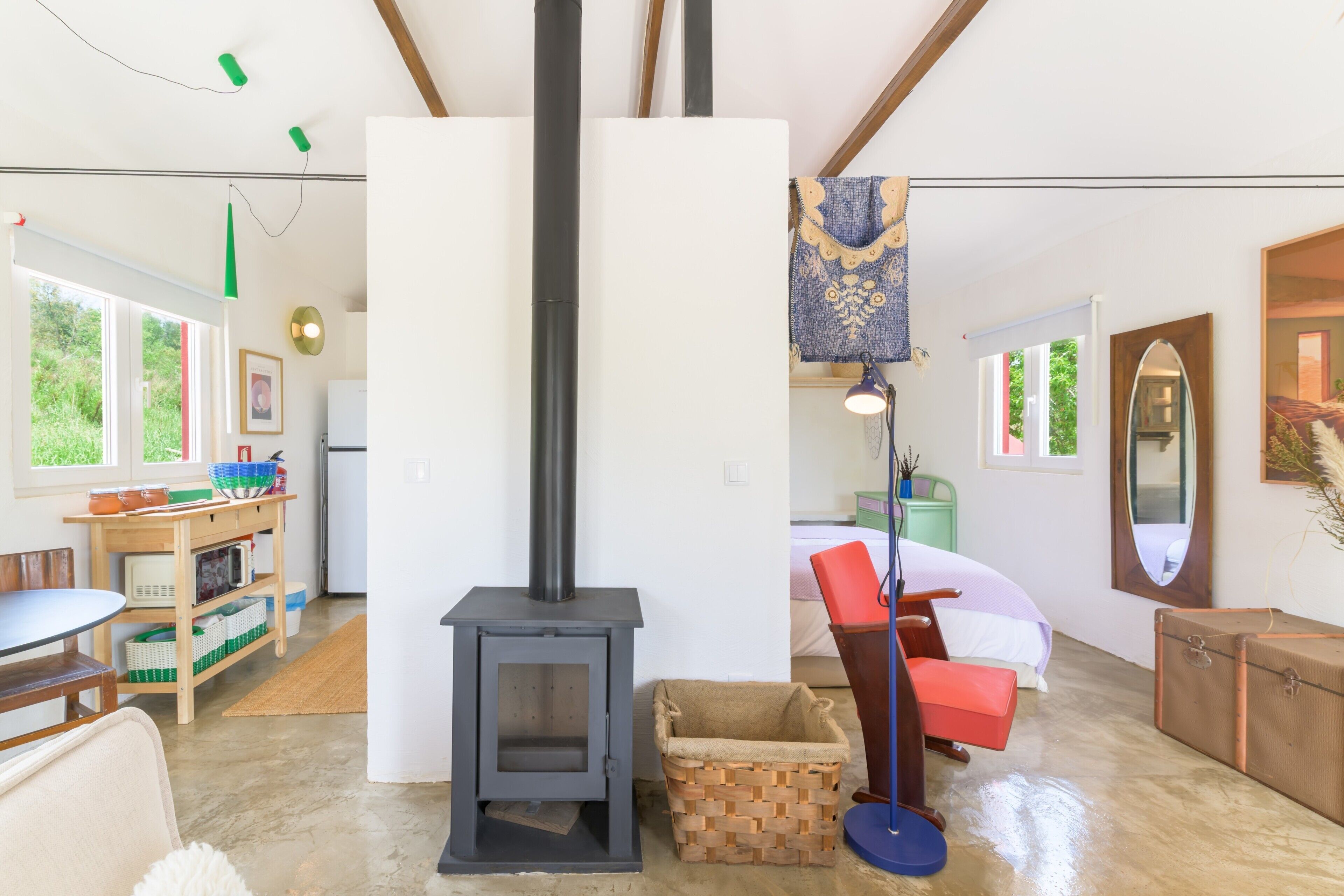 A cozy room with a fireplace, a bed, a table, and a window.