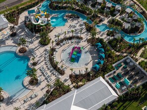 An aerial view of a resort with multiple swimming pools, water slides, and sun loungers. - 10BR Home w/ Pool & Disney Themes (Clermont)