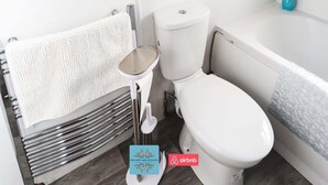 A bathroom with a toilet, a towel rack, and a bathtub. - 3BR House in Wolves | Ideal for Contractors + Wifi (West Midlands)