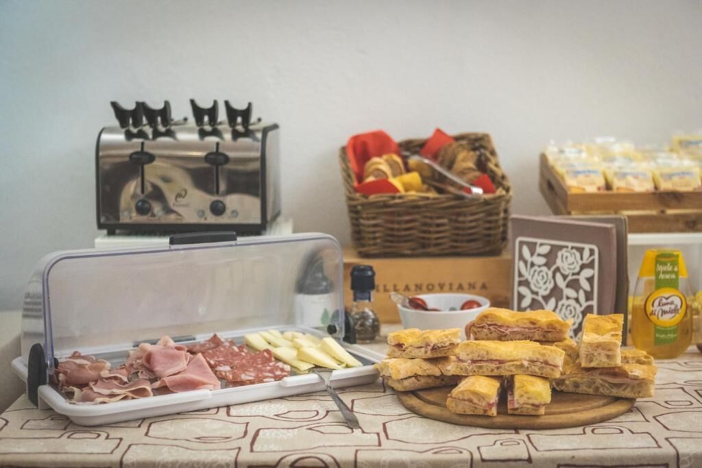 Una mesa de buffet con diferentes alimentos, un tostador y una cesta de pan.