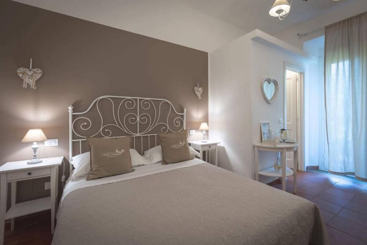 A bedroom with a bed, nightstands, a dresser, and a mirror.