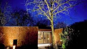 Ein modernes Gebäude mit Ziegelaußenwand, Glastür und einem Baum im Vordergrund.
