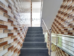 A staircase with a modern design, flanked by patterned walls, leading to an upper level.
