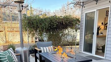 Eine Terrassenausstattung mit Feuerstelle, Sitzgelegenheiten und einer Pergola.