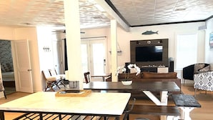 Un soggiorno moderno con zona pranzo, TV a parete e camino.
