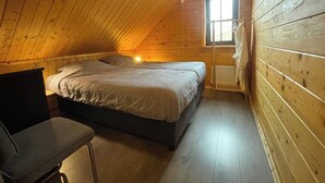 A small, cozy attic bedroom with a single bed, a chair, and a window. - Forest Villa, Rural Twente (Den Ham)