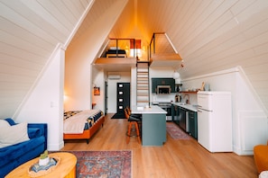 A loft-style apartment with a kitchen, dining area, and a bedroom with a loft bed. - Hickory Hollow | Hocking Hills, Hot Tub, Romantic (McArthur)