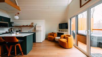 A modern kitchen with a central island, bar stools, and a large sliding glass door leading to an outdoor area.