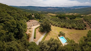 Una villa con piscina, immersa nel verde e circondata da dolci colline.