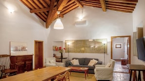 Un accogliente soggiorno con un tavolo da pranzo in legno, un divano e un televisore.