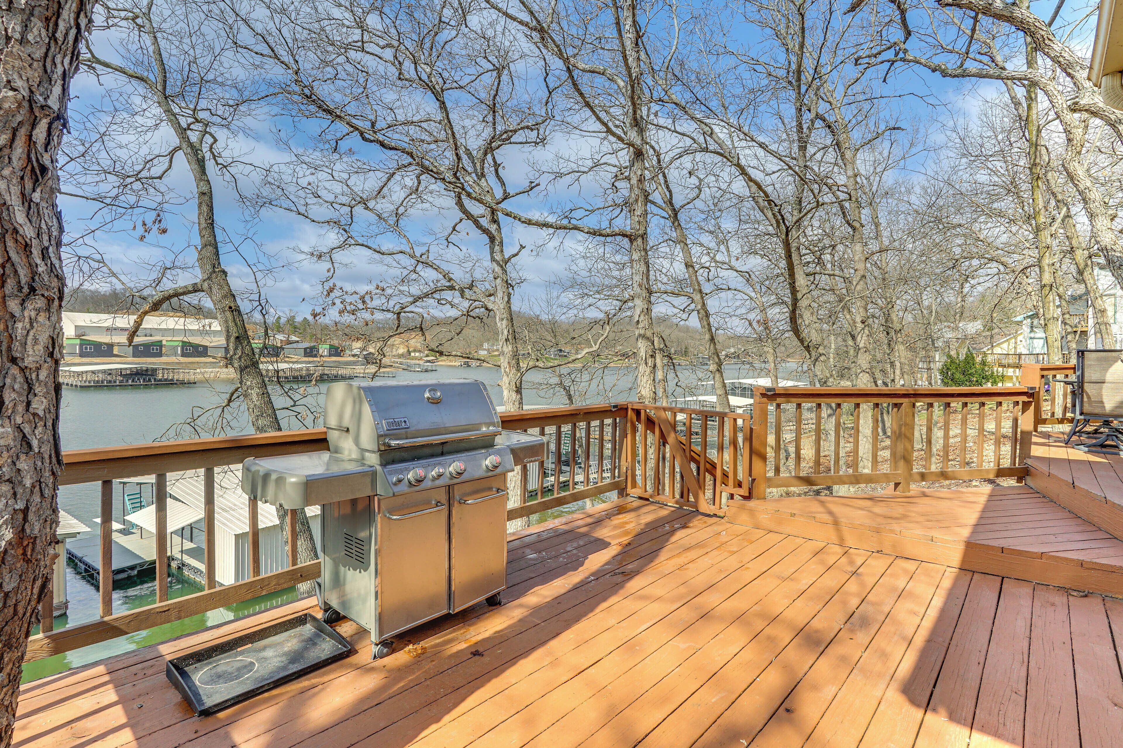 A wooden deck with a grill and a view of a river.