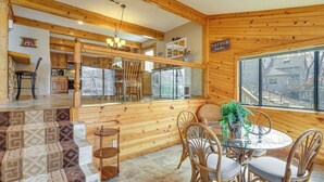 A wooden interior with a dining area, kitchen, and a view through a window. - Private Dual-slip Dock! Lake of the Ozarks Home (Gravois Mills)