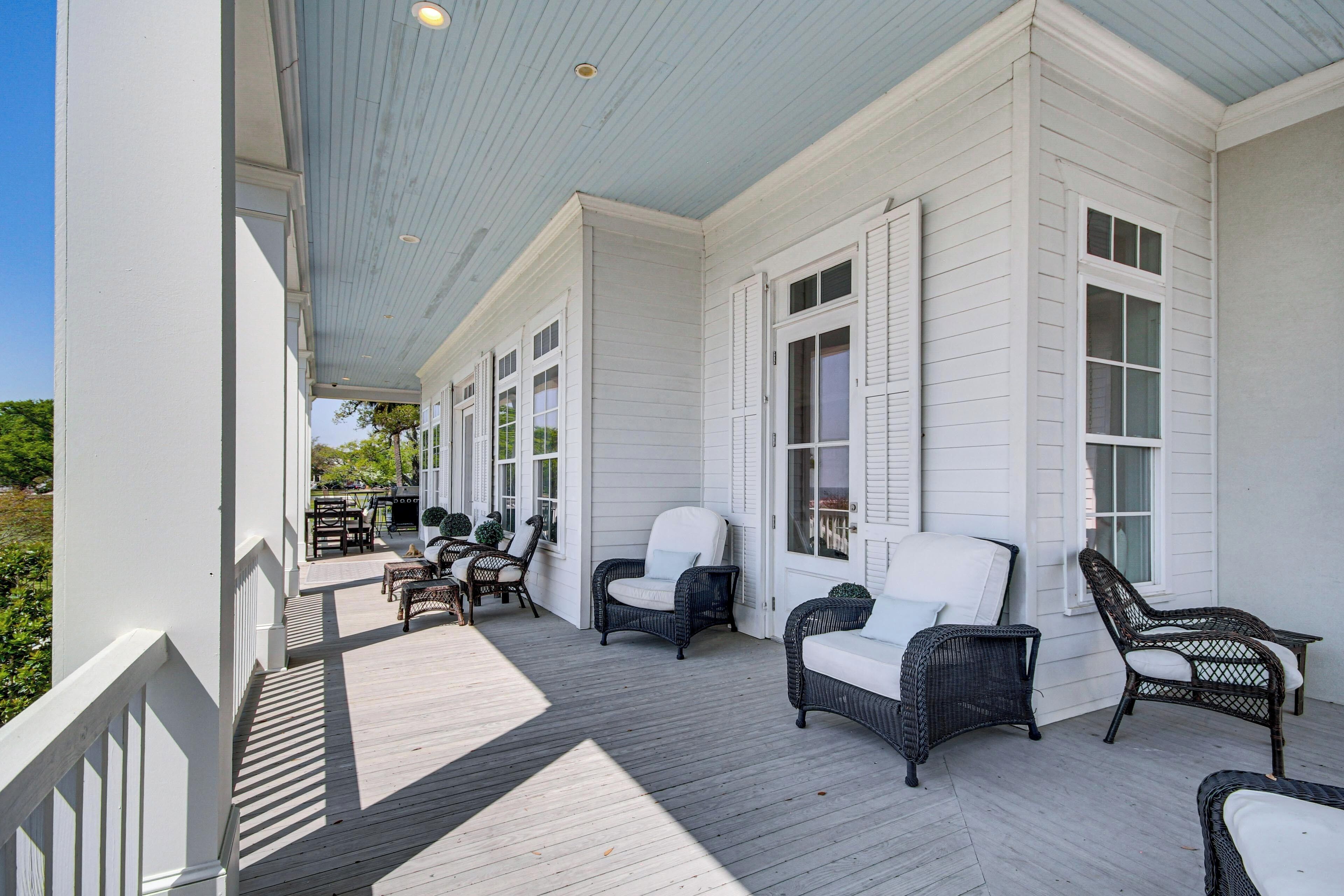 A covered porch with wicker furniture and a view of the outdoors.