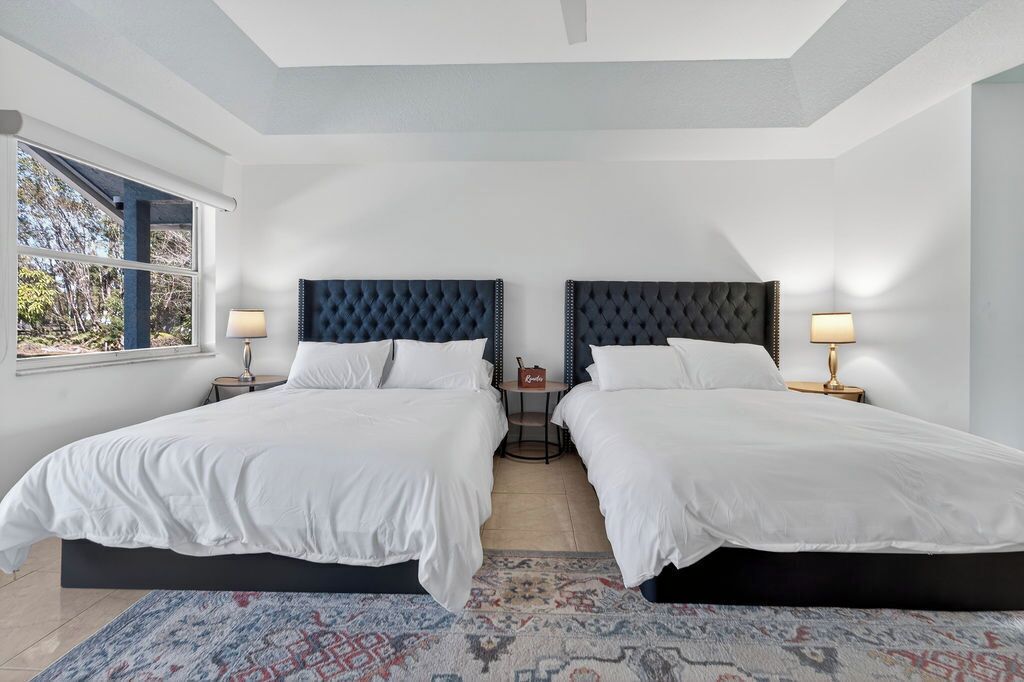 Sink into luxurious comfort with two plush beds featuring elegant tufted headboards and premium linens in your peaceful retreat.