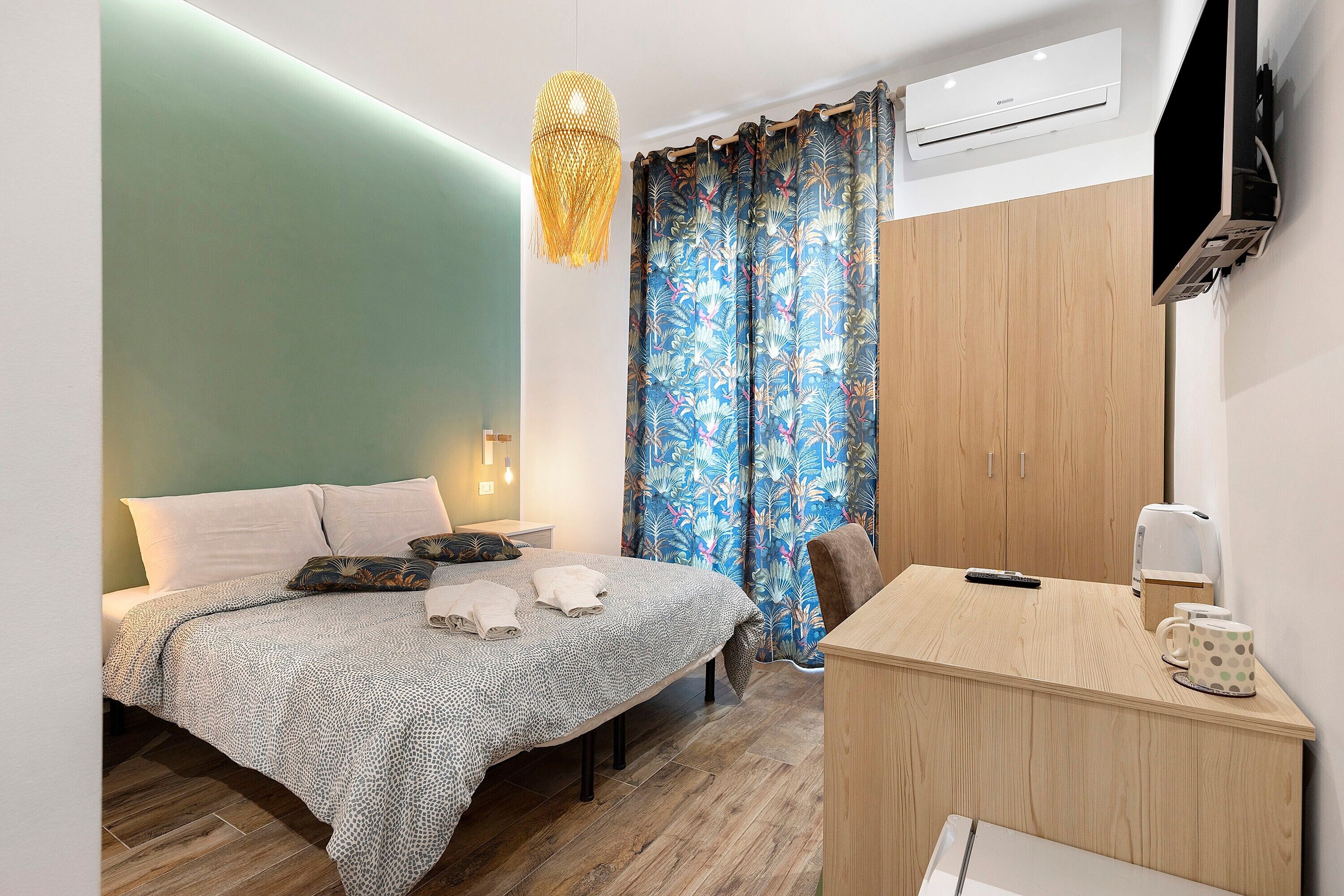 Une chambre d’hôtel moderne équipée d’un lit, d’une table de chevet et d’un bureau avec une chaise.