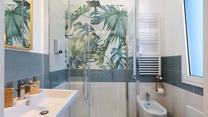 Un baño con ducha, bidé y lavamanos.