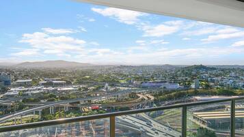A cityscape with a prominent highway interchange and a distant mountain range.