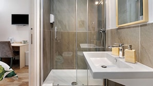 A modern bathroom with a glass-enclosed shower, a white sink, and a mirror above it. - Room 'Green Roof Palermo - 3 Rosmarino' with Balcony, Wi-Fi and Air Conditioning (Palermo)