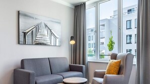 A modern living room with a grey sofa, a round coffee table, and a grey armchair. - 4 Star Holiday Home in Travemunde (Lübeck)