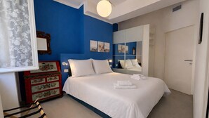 Um quarto com cama, penteadeira, espelho e guarda-roupa.