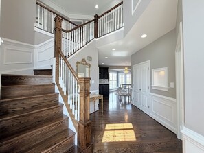 Un magnifique escalier en bois, avec des marches en bois et des balustrades blanches, menant à un deuxième étage.
