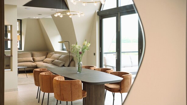 A modern dining area with a large table, several chairs, and a vase of flowers. - Country Holiday Home for 6 Guests (Den Burg)