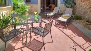 Ein Innenhof mit Außenbestuhlung, einer Treppe und Blick ins Innere.
