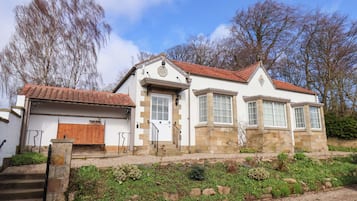 A two-story house with a red-tiled roof, a front door, and a garage.