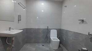 Een moderne badkamer met een wastafel, toilet en douche.