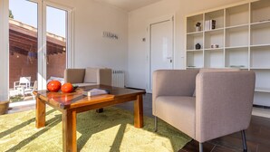 En moderne stue med et træsofabord, en beige sofa og en reol.