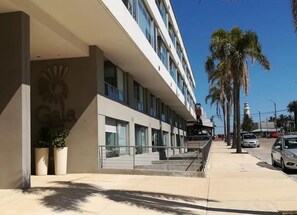 A modern hotel with a sign reading 'Gala,' a multi-story structure, and a palm tree-lined street. - MODERNO, COMODO & SEGURO vive Punta Día & Noche!! (Punta del Este)