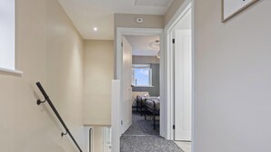 Un couloir avec un radiateur, une porte et une fenêtre.