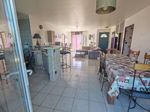 Un vaste espace de vie comprenant une table à manger, un canapé et un coin cuisine.