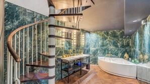 Un bagno moderno con parete in marmo, una scala a chiocciola in legno, un mobile lavabo con lavandino e una vasca da bagno.