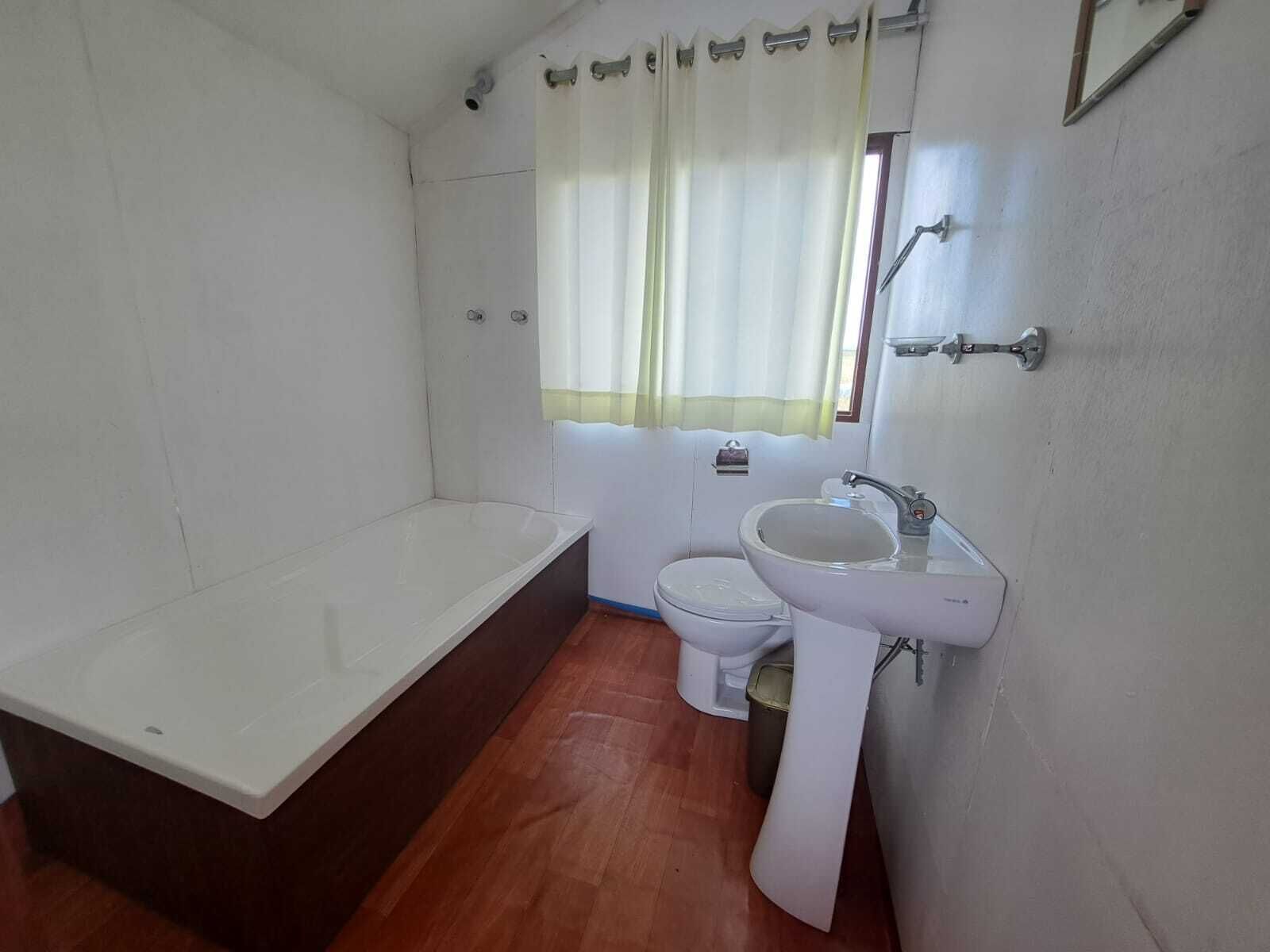 A bathroom with a bathtub, toilet, and sink.