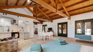 A spacious living area with a high wooden ceiling, a dining table, and a sofa. - Apartment 'Marina' with Shared Pool, Garden, and Wi-Fi (Jesolo)
