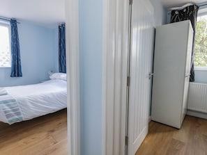A bedroom with a bed, a wardrobe, and a radiator. - Clifftop House (Bournemouth)