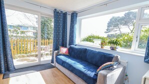 A room with a sofa, a window, a radiator, and a view of the outside. - Clifftop House (Bournemouth)