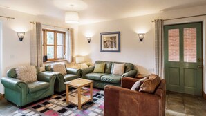 A living room with a green sofa, a wooden coffee table, and a patterned rug.