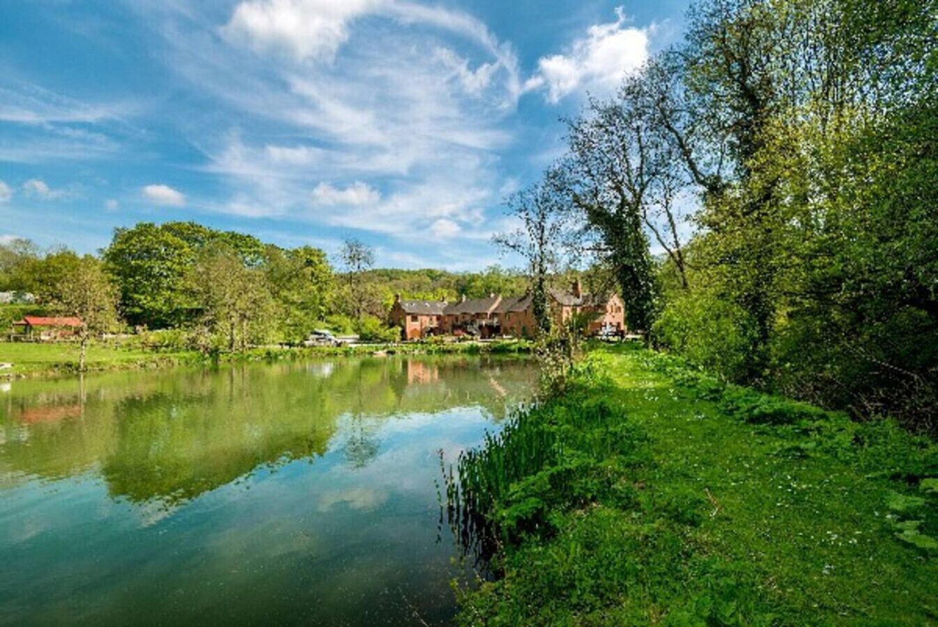 Un entorno tranquilo junto al lago, con una casa y un pequeño bote amarrado al agua.