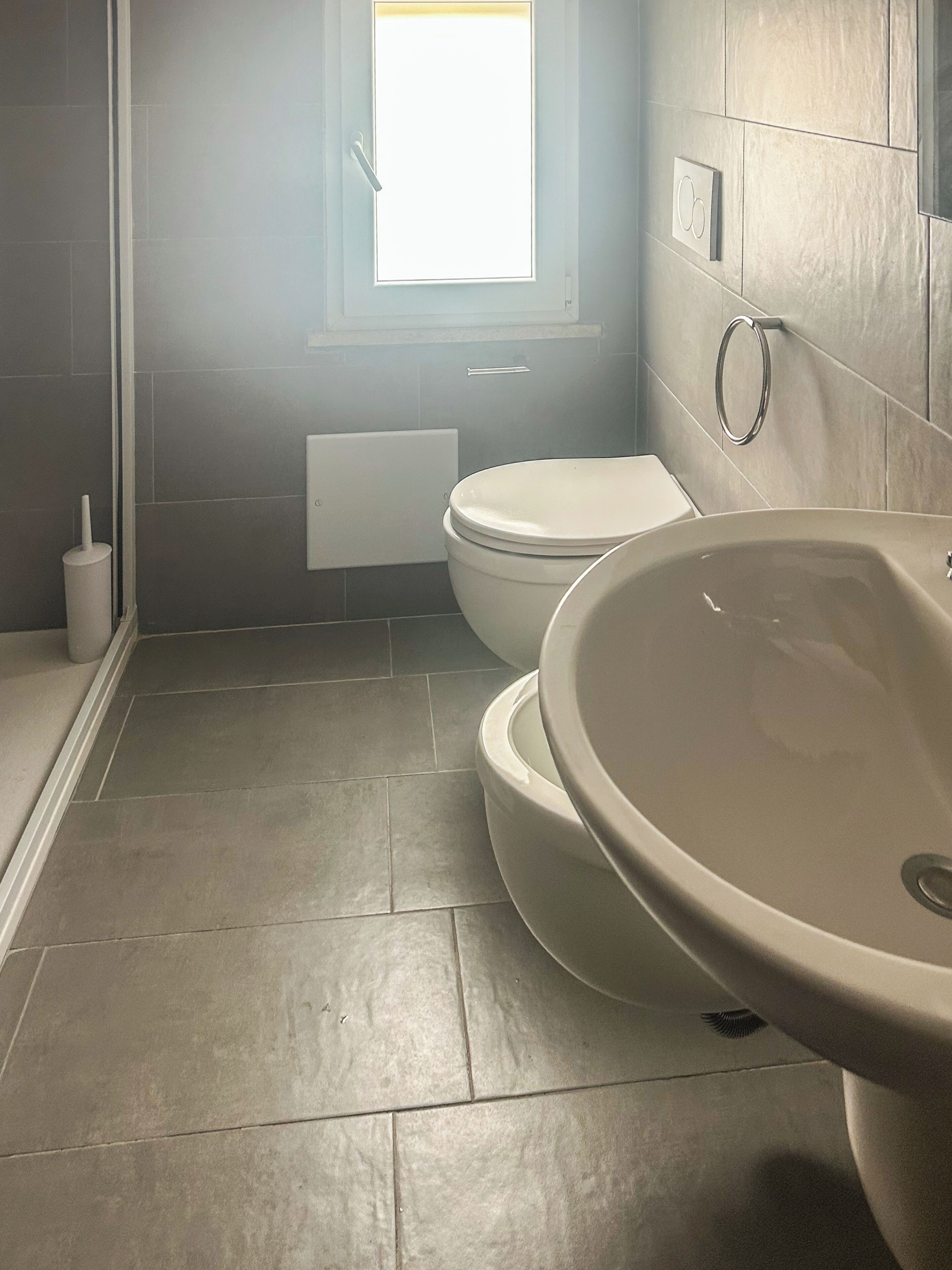 Un baño con inodoro, lavamanos y ventana.