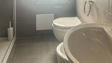 Un baño con inodoro, lavamanos y ventana.