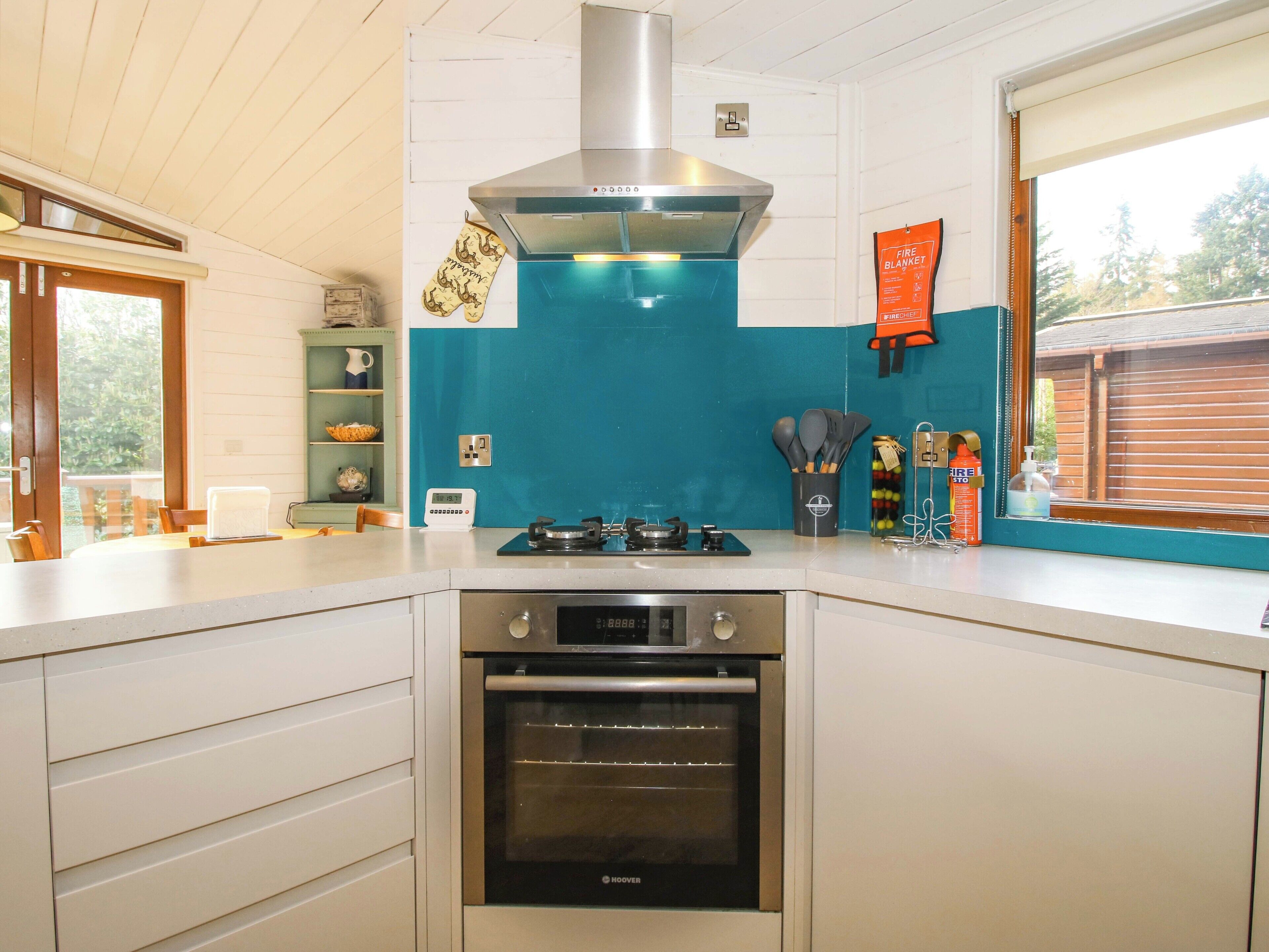 A kitchen with a stove, oven, and a blue backsplash.