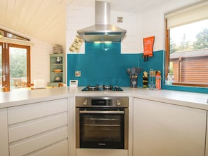 Une cuisine équipée d’une cuisinière, d’un four et d’un plan de travail bleu.
