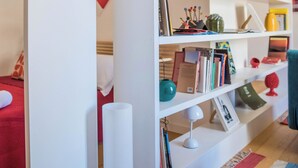 A white bookshelf with various decorative items and books. - Adenzia Apartment (Palermo)