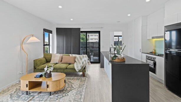 A modern apartment with a living area, kitchen, and balcony.