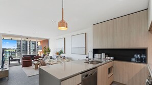 Una cocina moderna con una isla central, electrodomésticos integrados y un comedor con asientos.