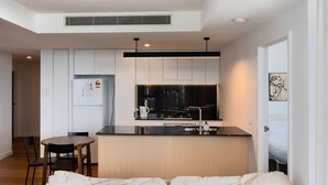 Un apartament modern amb cuina, zona de menjador i saló.